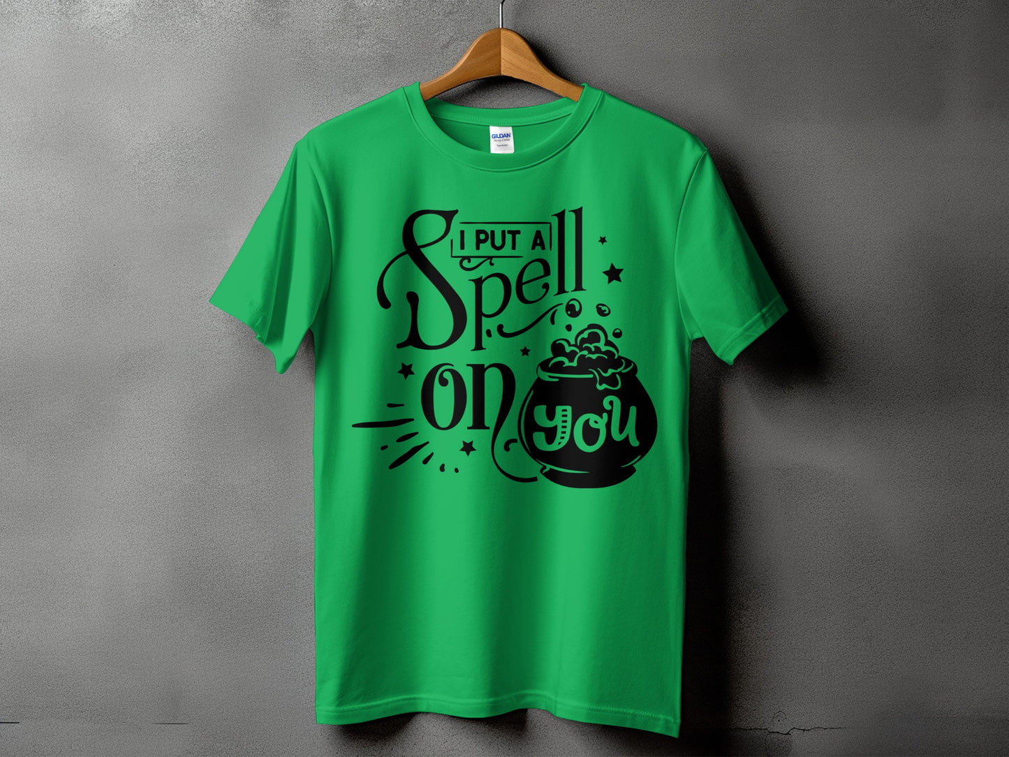 Green t-shirt with "I put a spell on you" text and cauldron graphic.