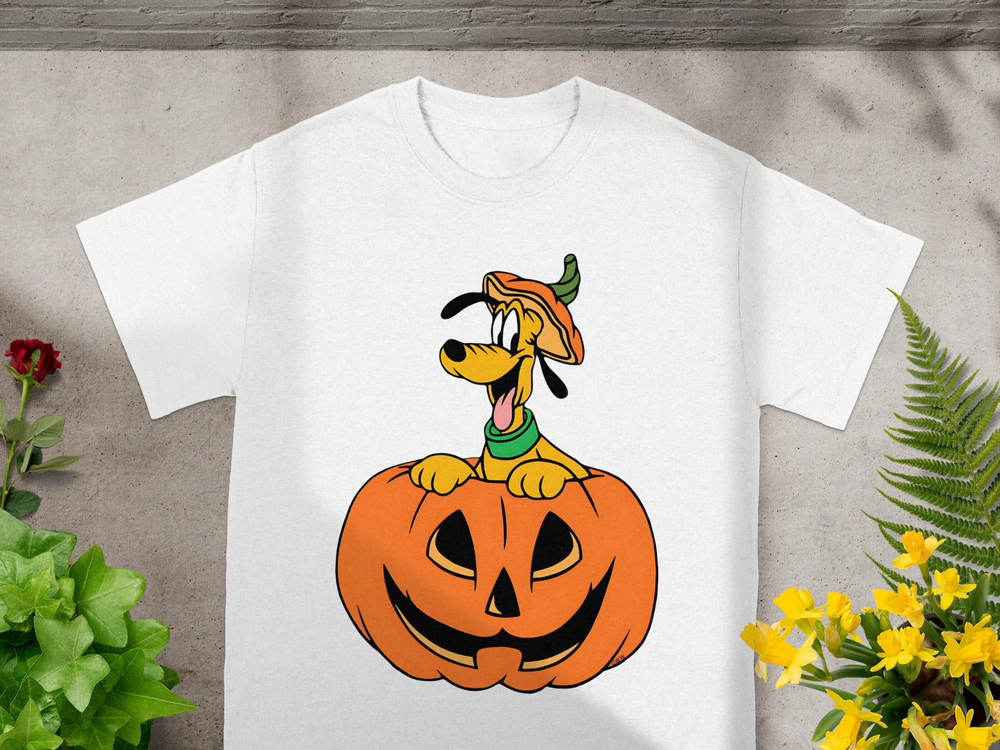 White t-shirt featuring a cartoon of Pluto peeking out of a jack-o'-lantern.