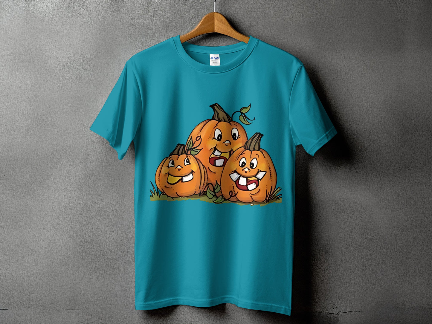 Teal t-shirt featuring three cartoon pumpkins with happy expressions.