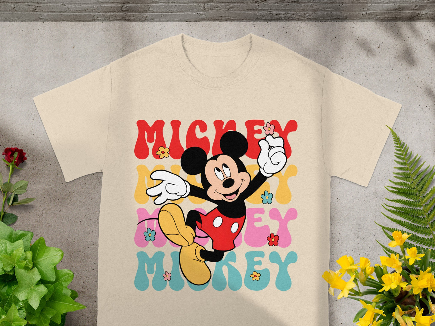Mickey Mouse graphic tee with colorful "Mickey" text and floral accents.