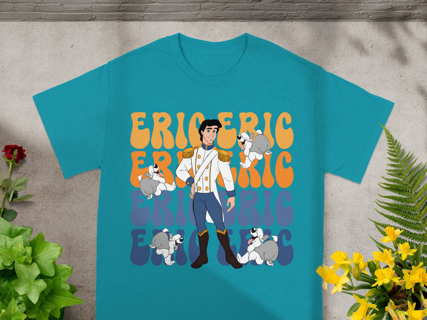 Prince Eric with dogs on a teal t-shirt with orange and yellow text.
