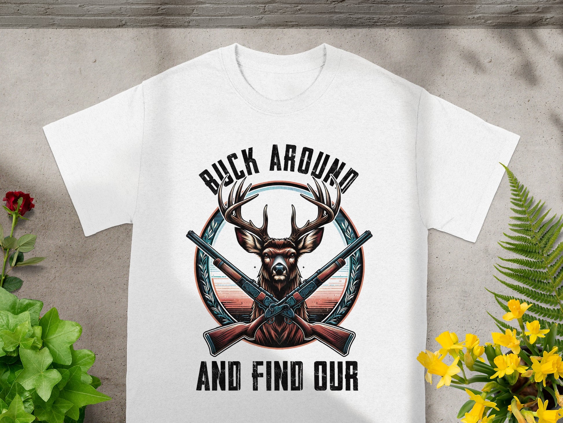 White t-shirt with deer, crossed rifles, and text "BUCK AROUND AND FIND OUR".