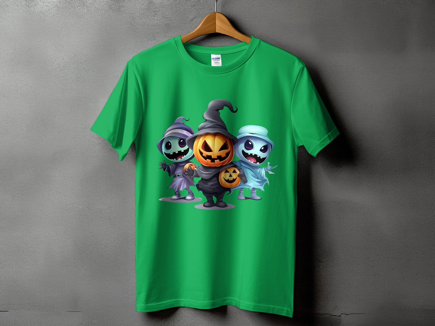 Green t-shirt with three cartoon Halloween characters: witch, pumpkin, and ghost.