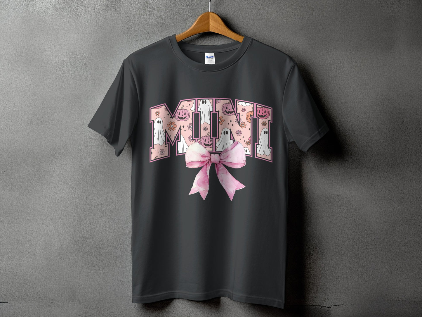 Dark gray t-shirt with "MINI" text in pink Halloween graphics and a pink bow.