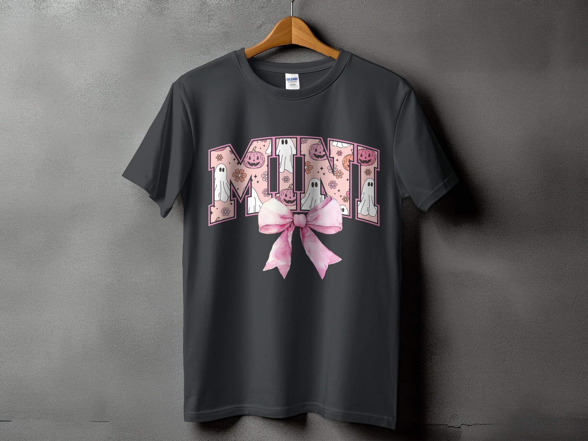 Dark gray t-shirt with "MINI" text in pink Halloween graphics and a pink bow.