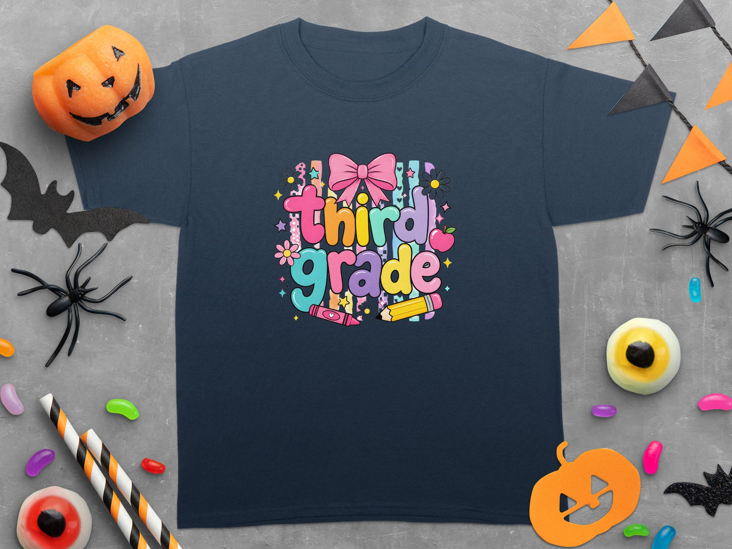 Navy t-shirt with colorful "Third Grade" text, bow, apple, crayon, and pencil graphics.