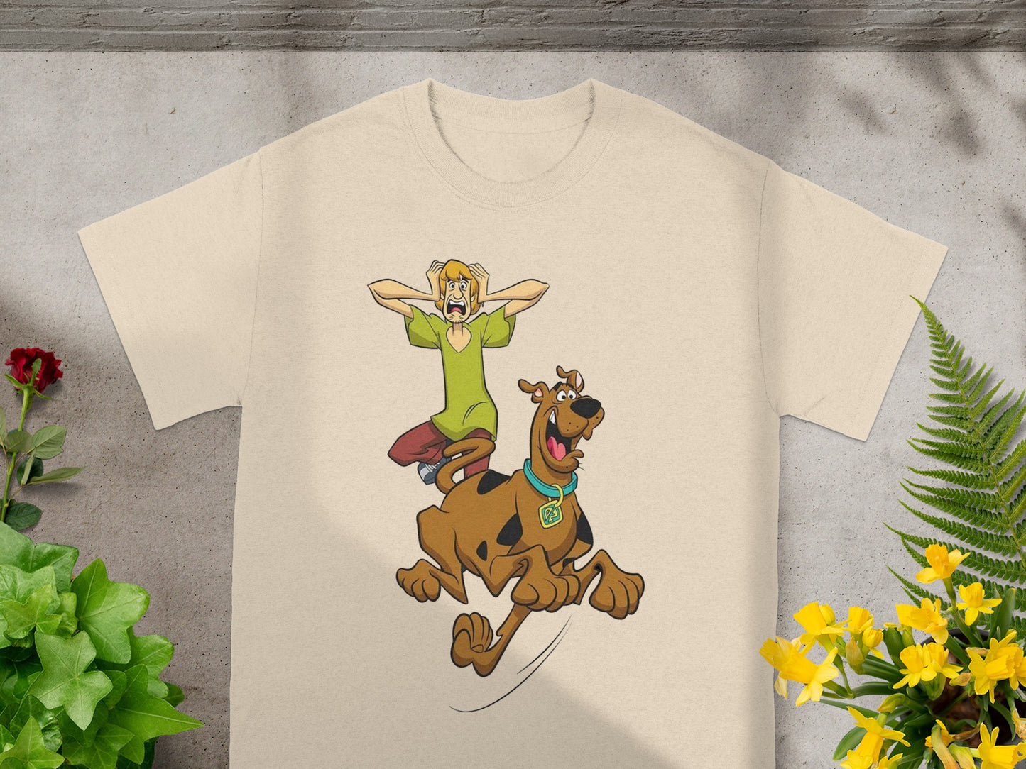 Shaggy and Scooby-Doo cartoon characters in flight on a tan t-shirt.
