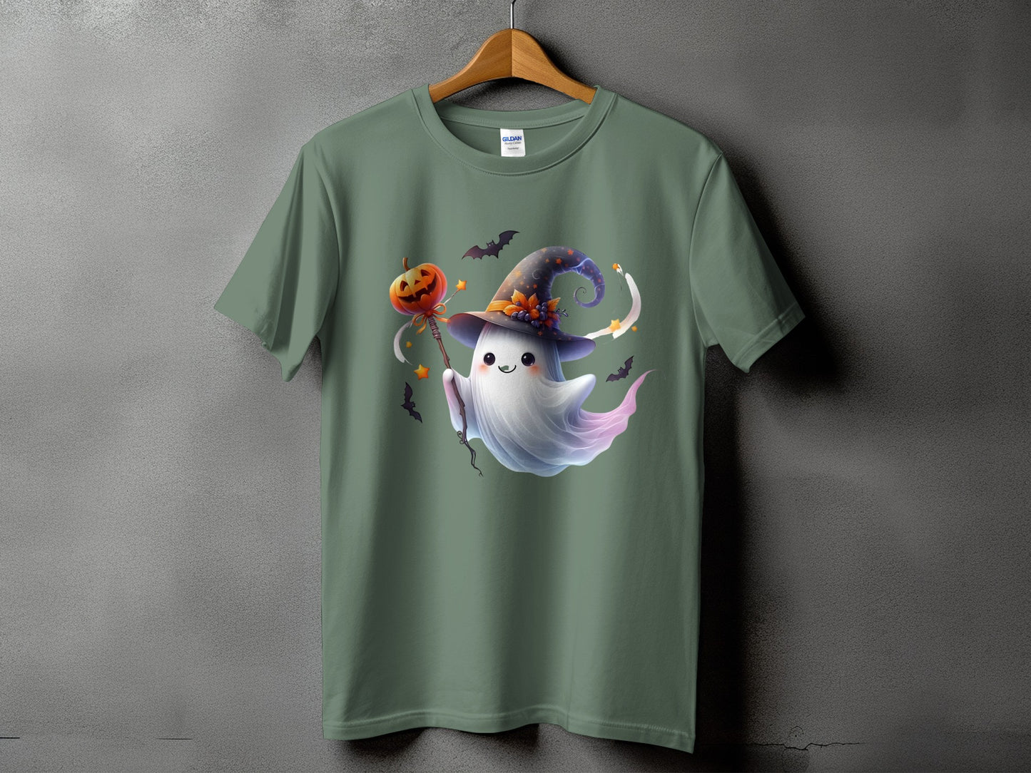 Green t-shirt with a cartoon ghost wearing a witch hat and holding a pumpkin staff.