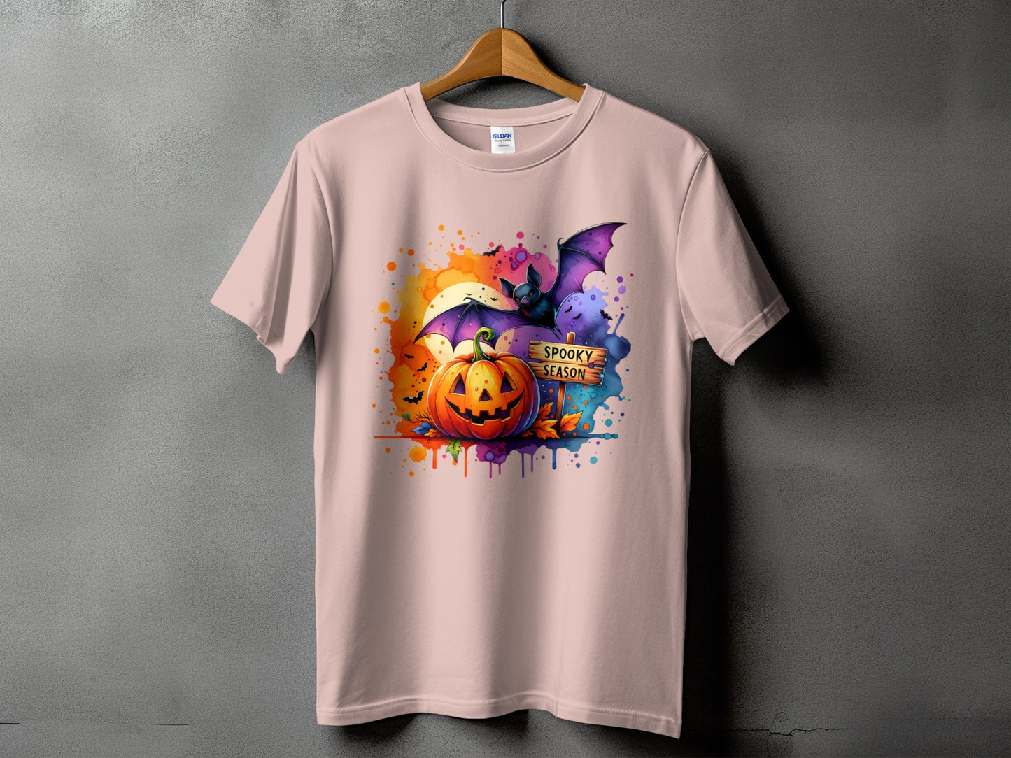 Halloween t-shirt with pumpkin, bat, and "Spooky Season" text on a watercolor background.