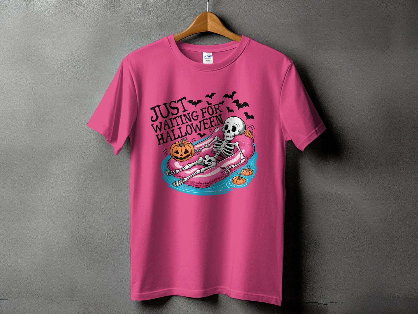 Pink t-shirt with skeleton on float, pumpkins, bats, and "Just Waiting For Halloween" text.
