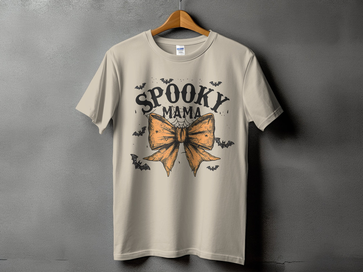 Light tan t-shirt with "Spooky Mama" text and an orange bow with bats.