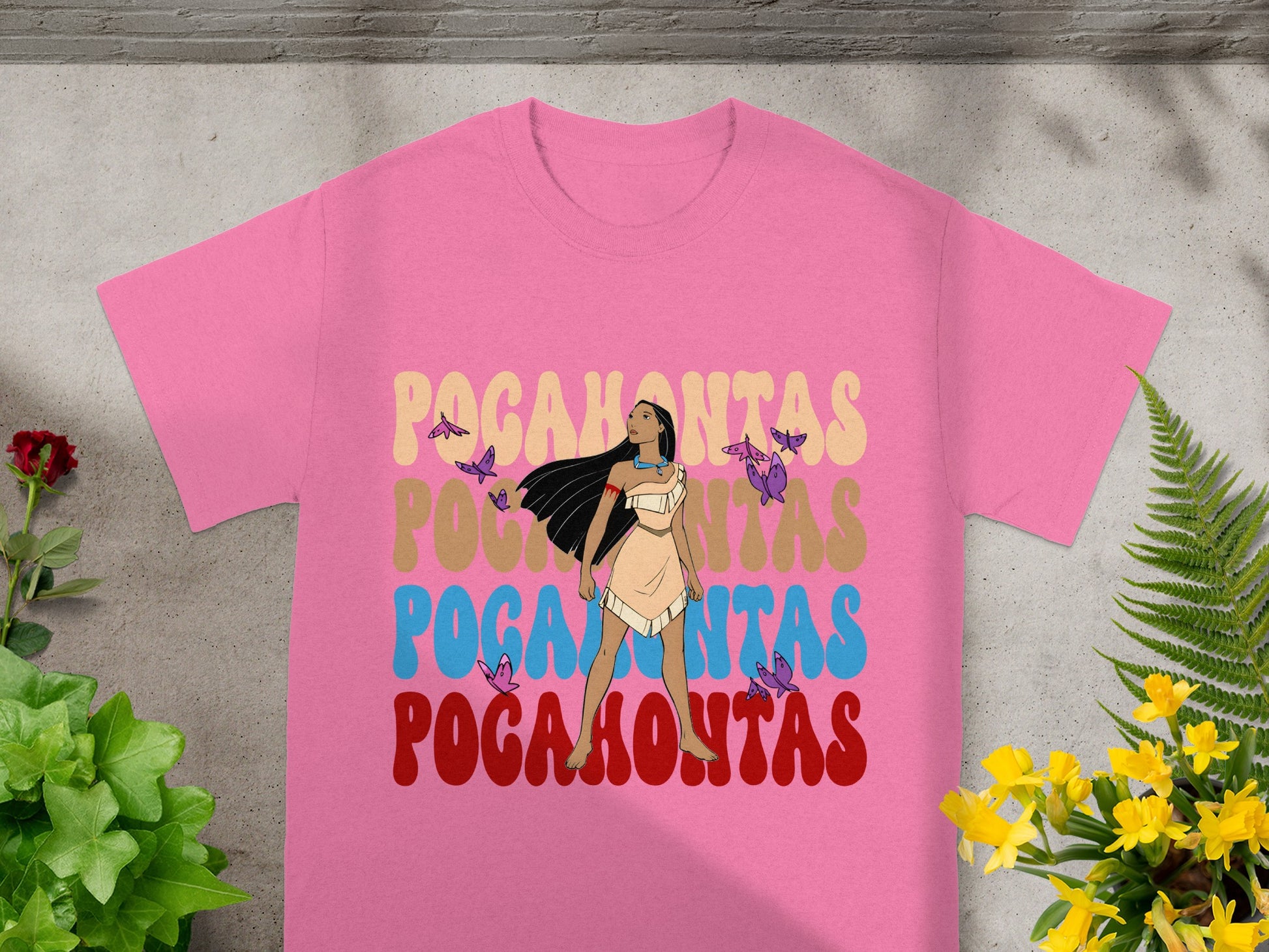 Pink t-shirt with "Pocahontas" in colorful retro font and butterfly accents.
