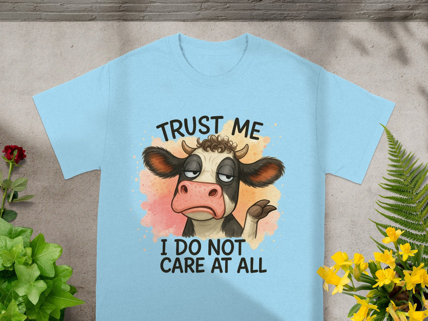 Light blue t-shirt with cartoon cow saying "Trust me, I do not care at all."