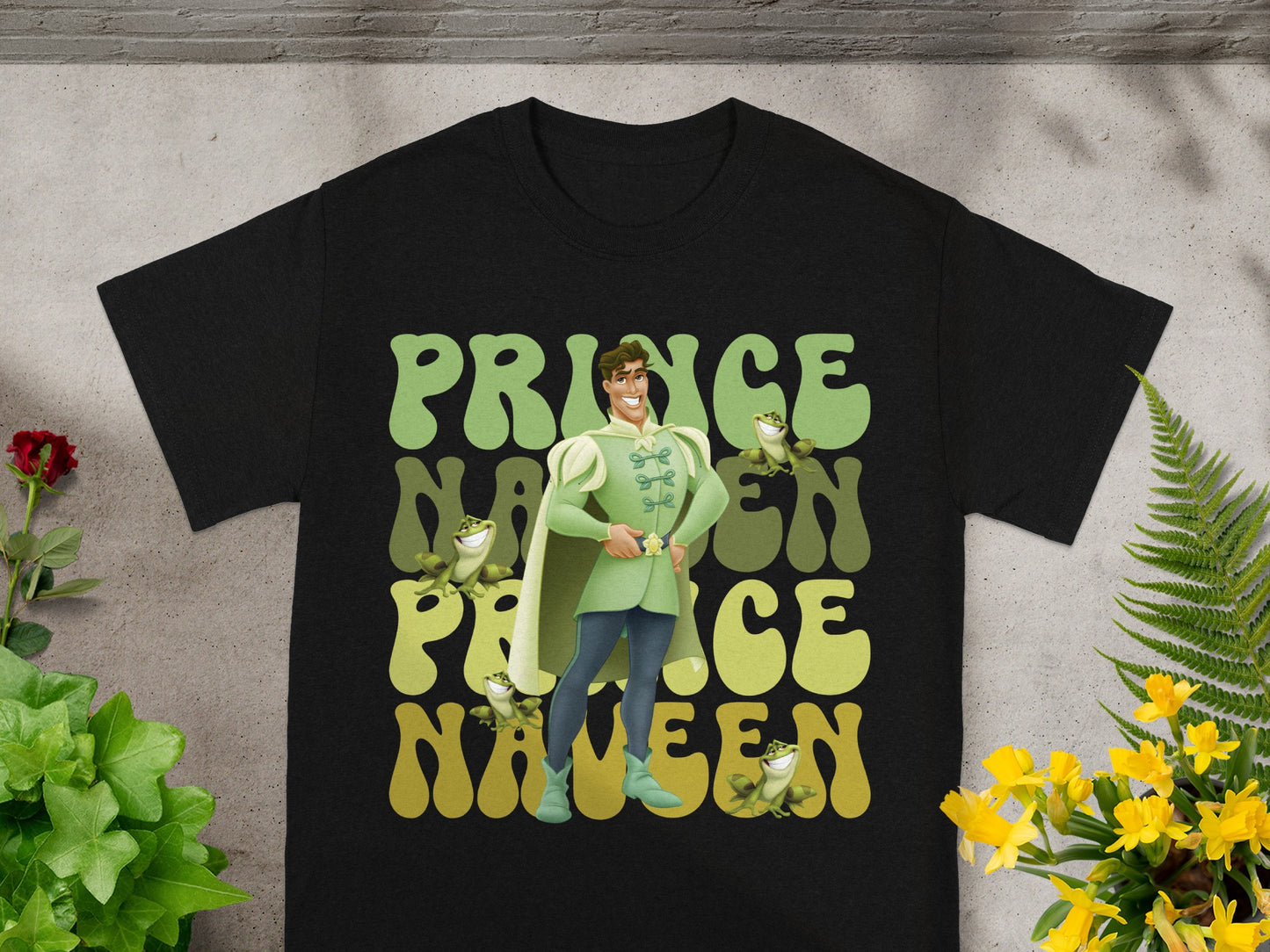 Black t-shirt with Prince Naveen graphic and frog illustrations.