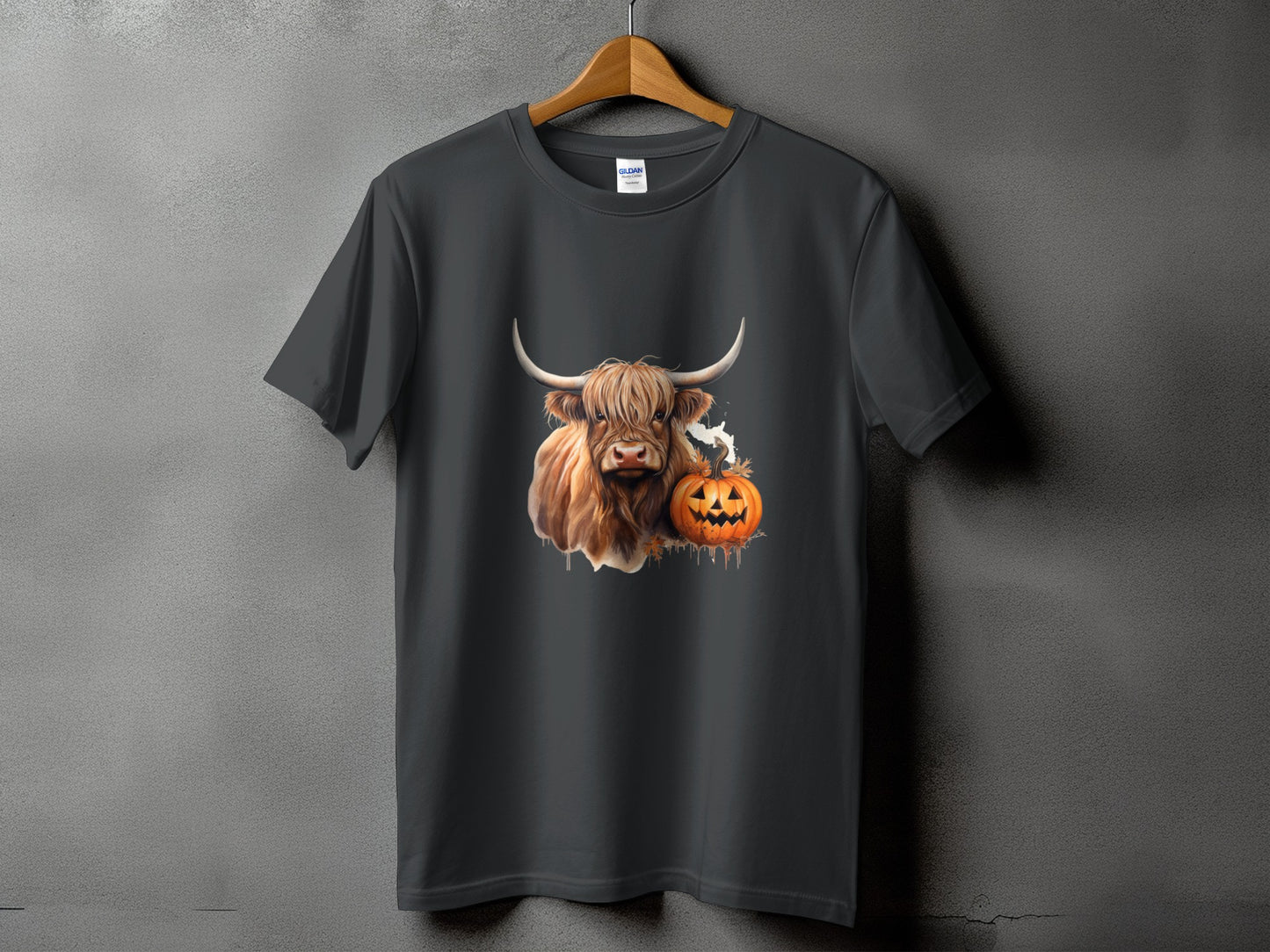 Highland cow with pumpkin and ghost graphic on a dark grey t-shirt.