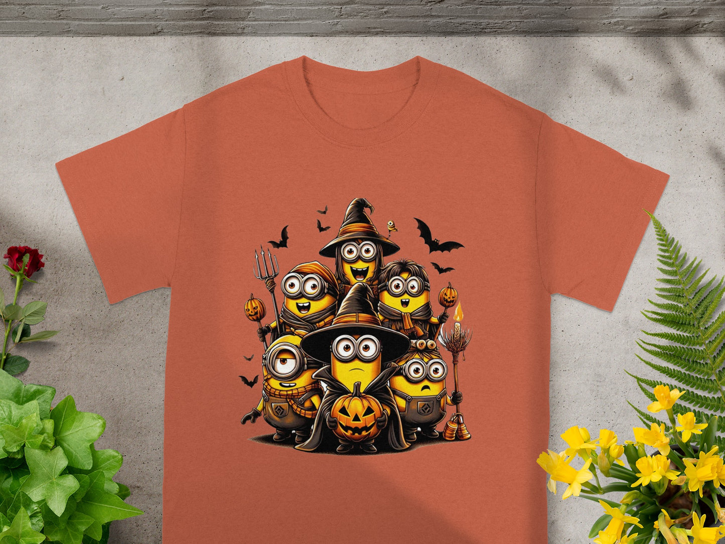 Minions in Halloween costumes holding pumpkins and brooms.