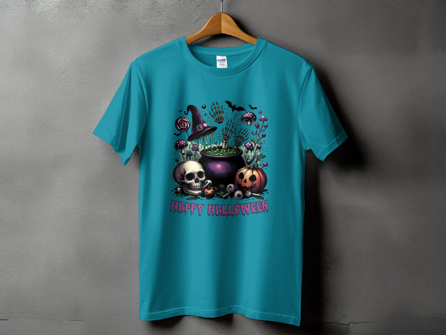 Teal t-shirt with Halloween graphic: skull, pumpkin, cauldron, witch hat, skeleton hands, and text.