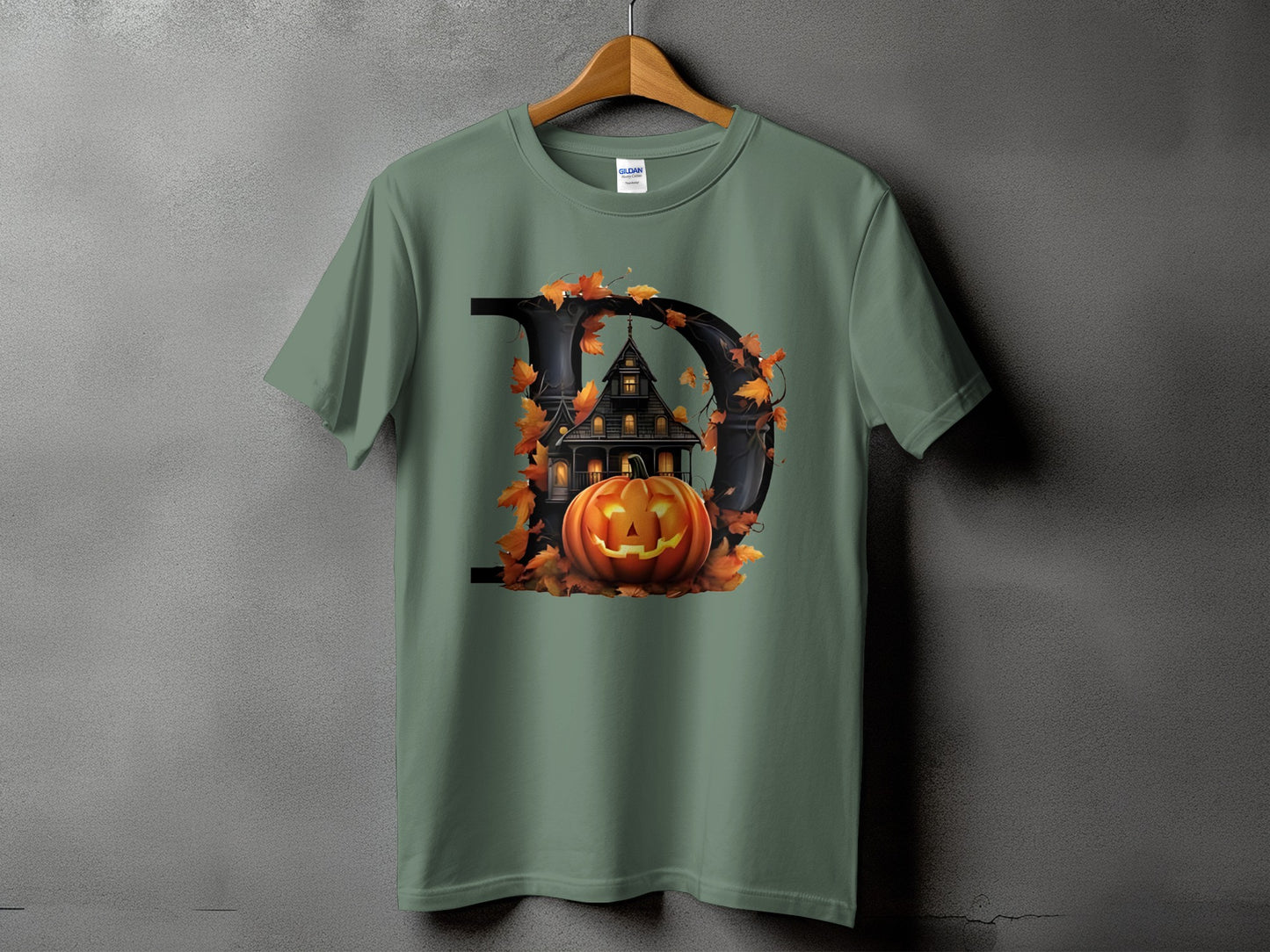 Green t-shirt with graphic of letter D, haunted house, pumpkin, and fall leaves.