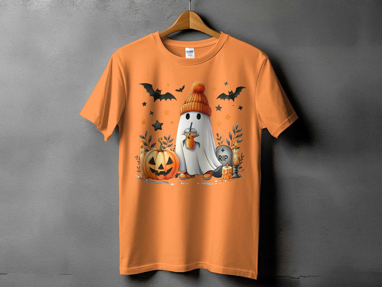 Orange t-shirt with a cartoon ghost, pumpkin, bats, and gravestone Halloween graphic.