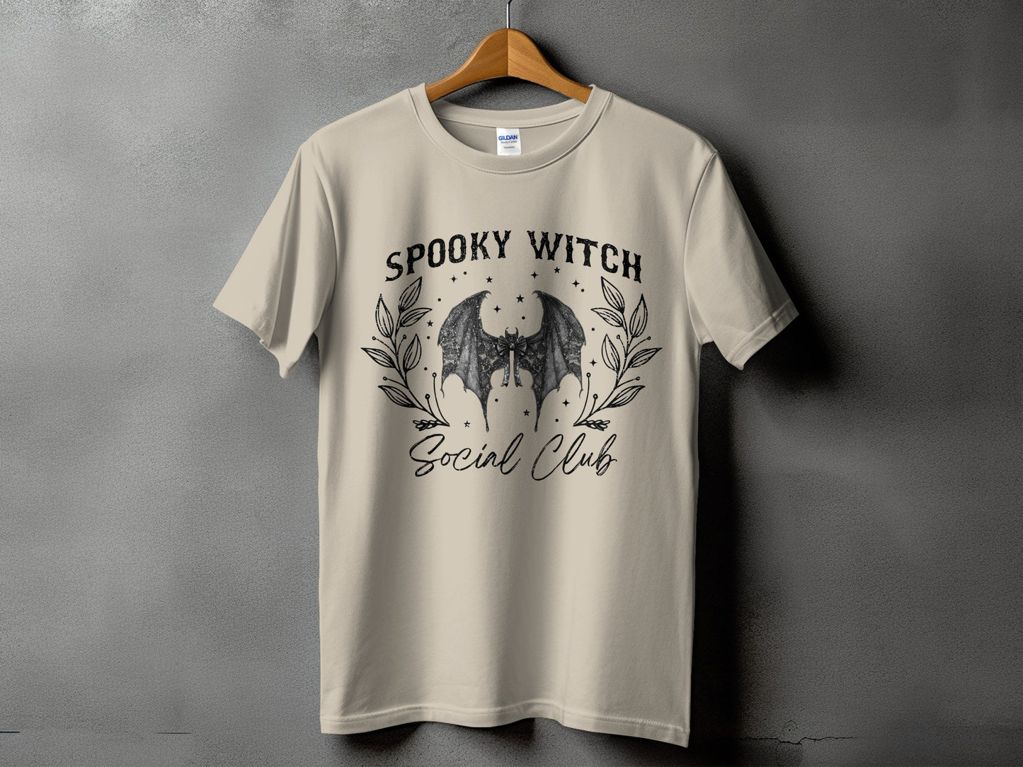 Tan t-shirt with "Spooky Witch Social Club" text and bat wings graphic.