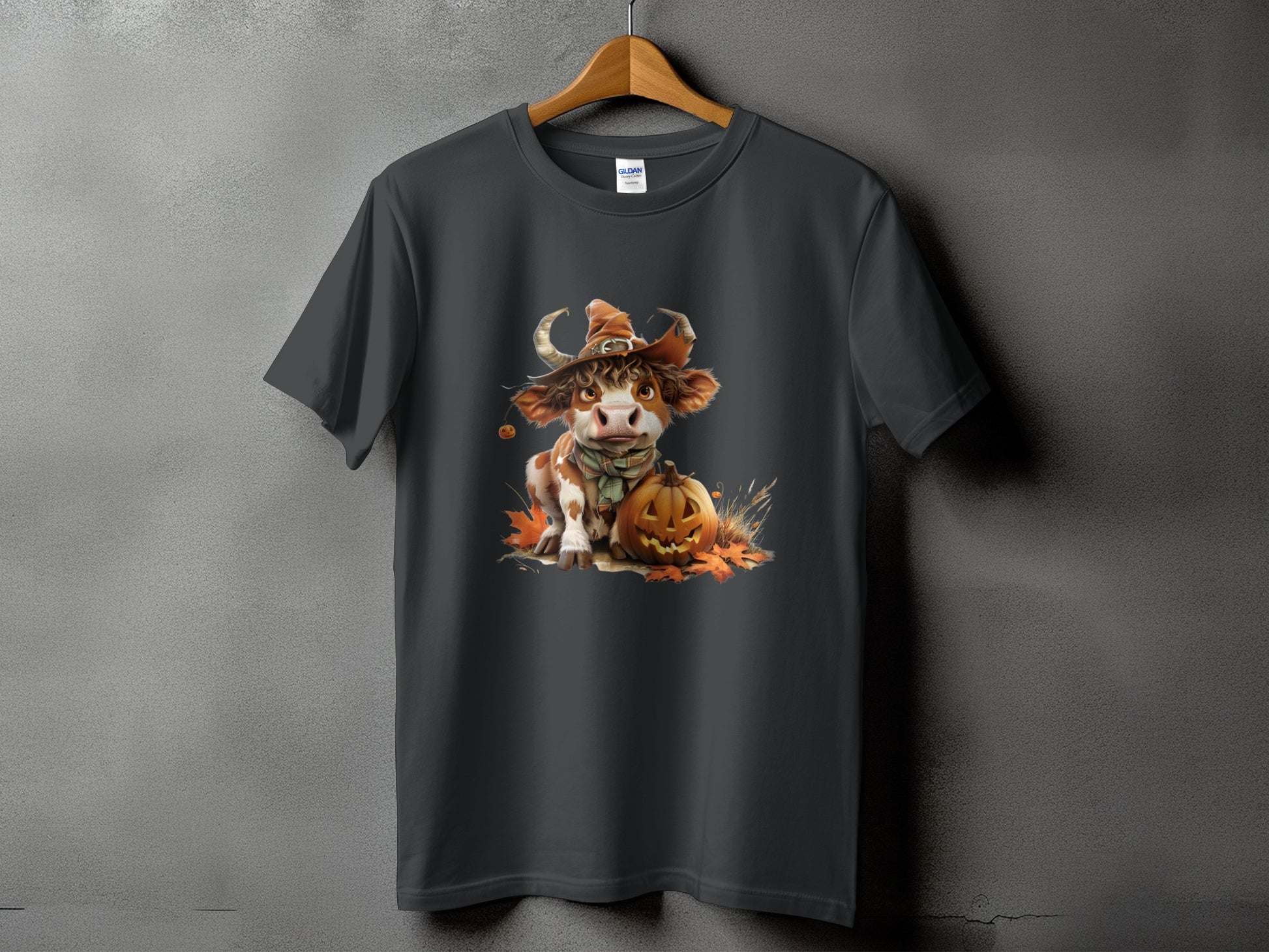 Dark grey t-shirt featuring a Halloween cow wearing a witch hat and scarf with a pumpkin.