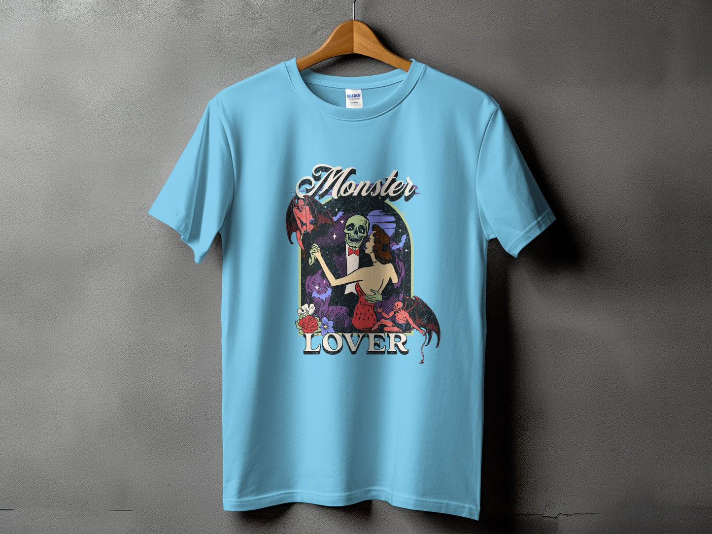 Light blue t-shirt with "Monster Lover" text and vintage art of dancing skeletons and demons.