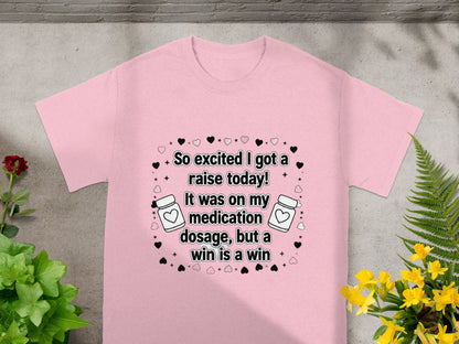Pink t-shirt with text "So excited I got a raise today! It was on my medication dosage, but a win is a win."