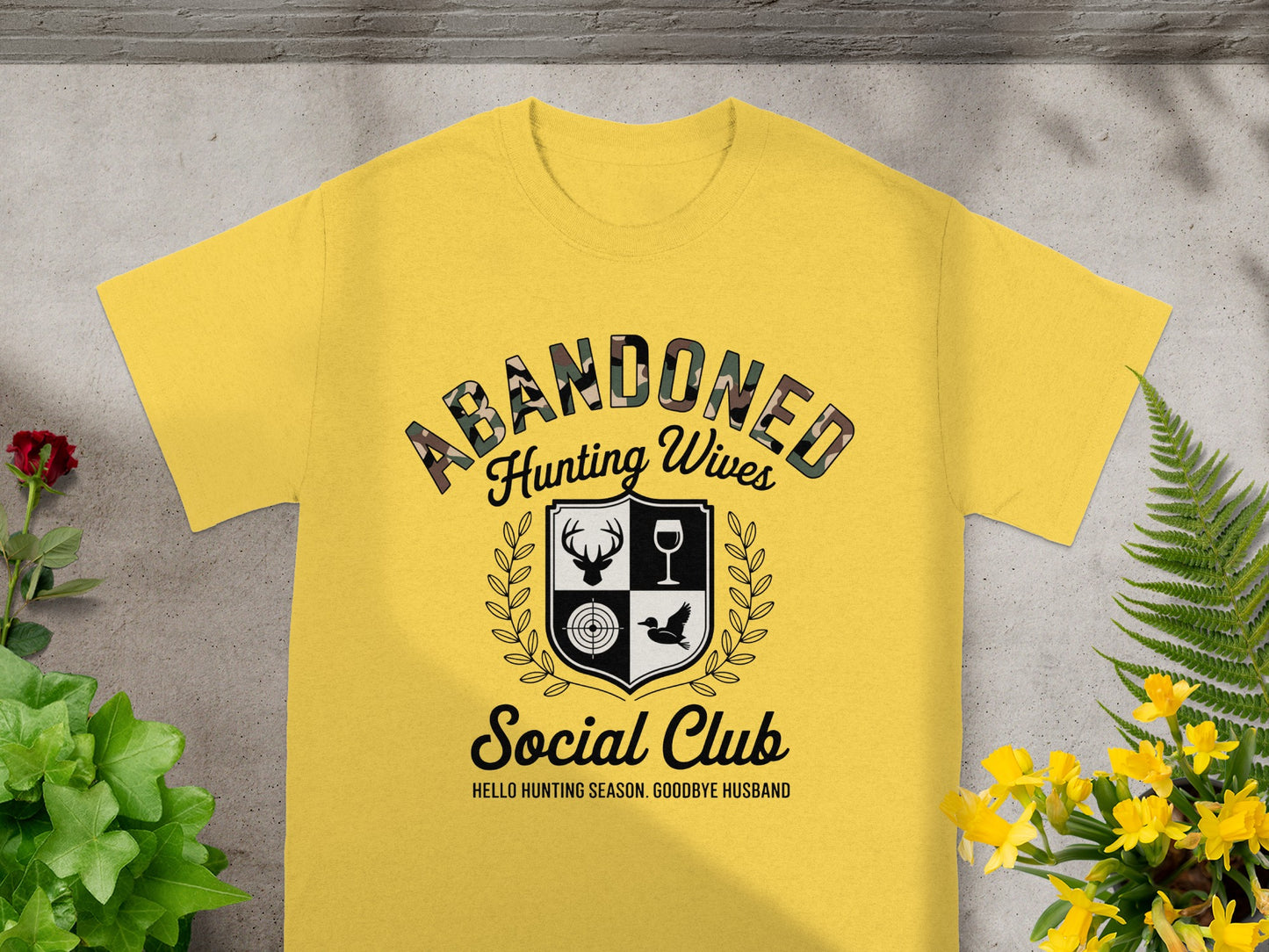 Yellow t-shirt with "Abandoned Hunting Wives Social Club" text and hunting graphics.