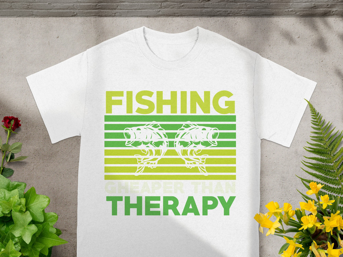 White t-shirt with "FISHING CHEAPER THAN THERAPY" text and two fish.