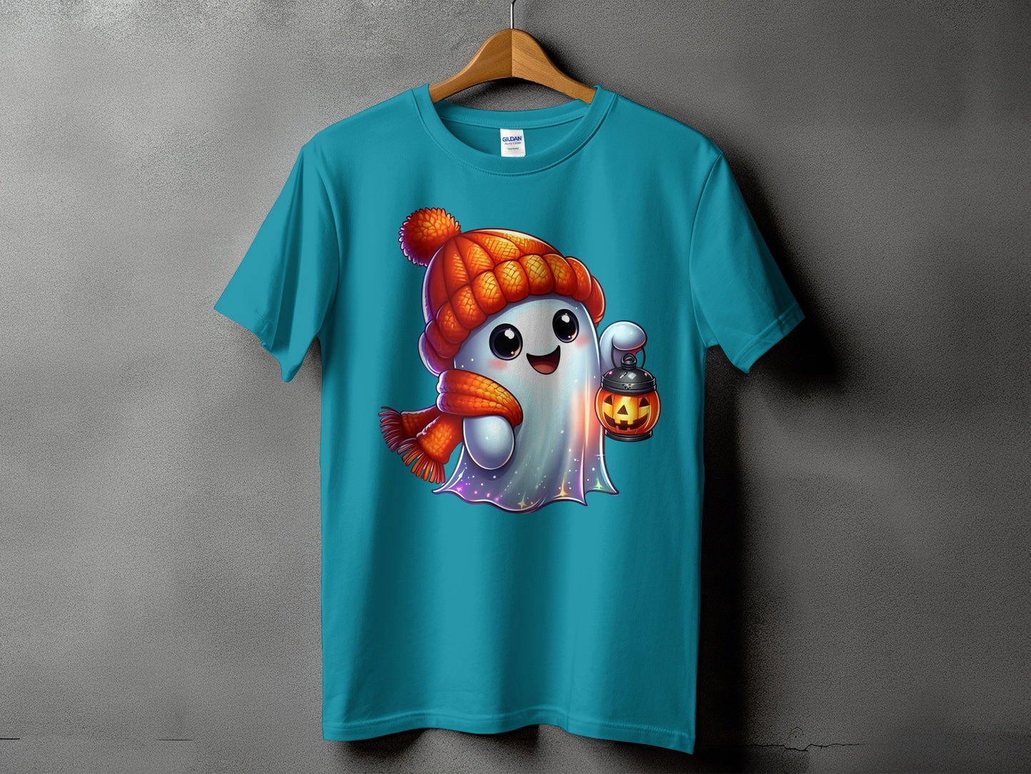 Turquoise t-shirt featuring a cartoon ghost wearing a hat and scarf, holding a jack-o'-lantern.