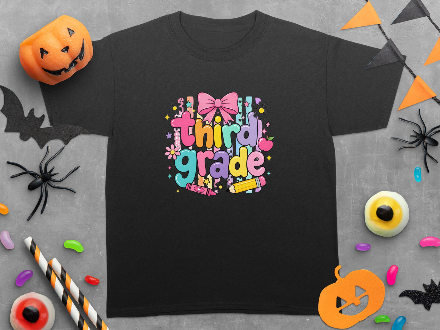Black t-shirt with "third grade" text design surrounded by Halloween and school-themed decorations.