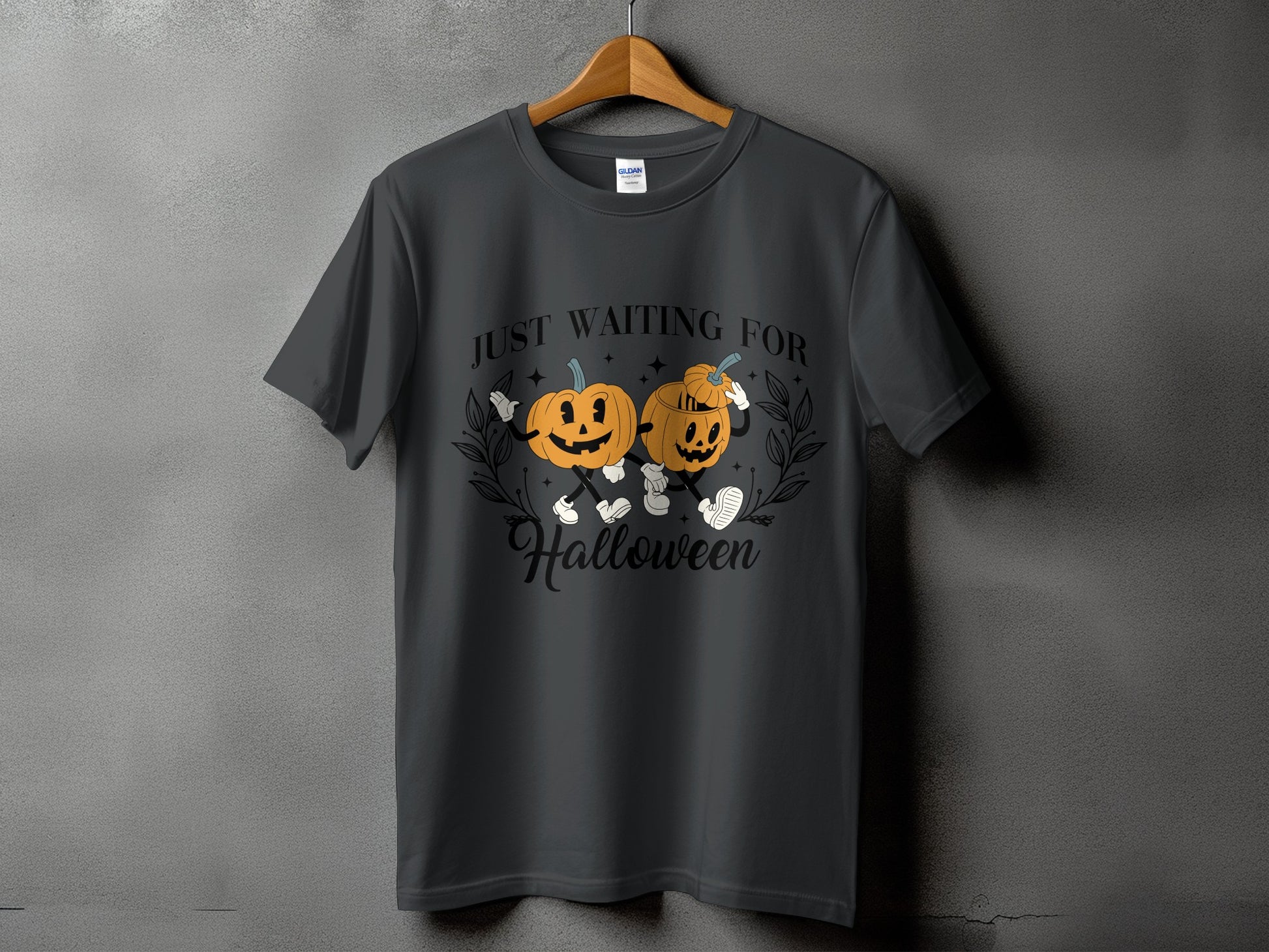 Dark gray t-shirt with two cartoon pumpkins and text "JUST WAITING FOR Halloween".