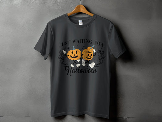 Dark gray t-shirt with two cartoon pumpkins and text "JUST WAITING FOR Halloween".