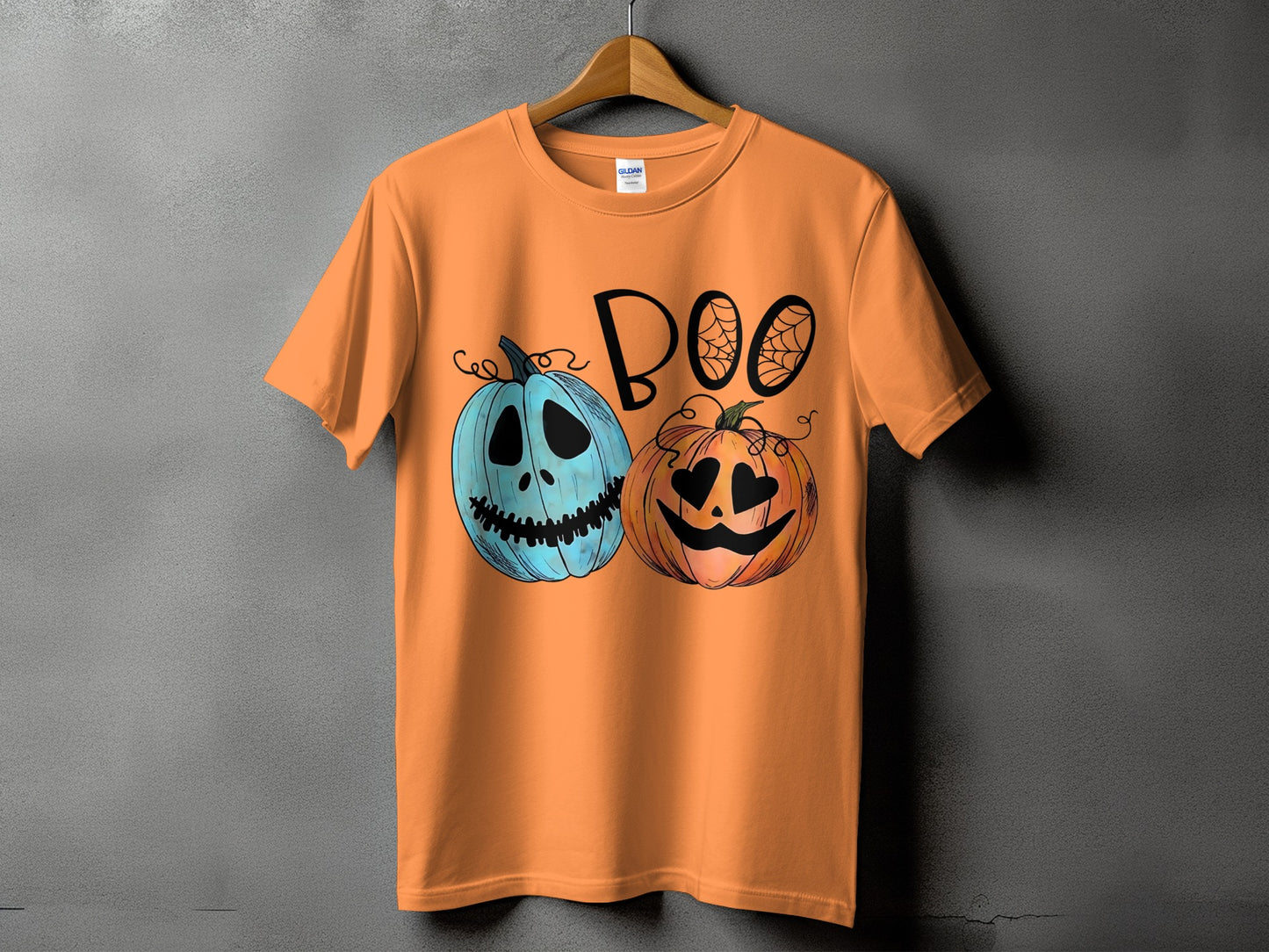 Orange t-shirt with "BOO" text and two cartoon pumpkins, one blue, one orange.