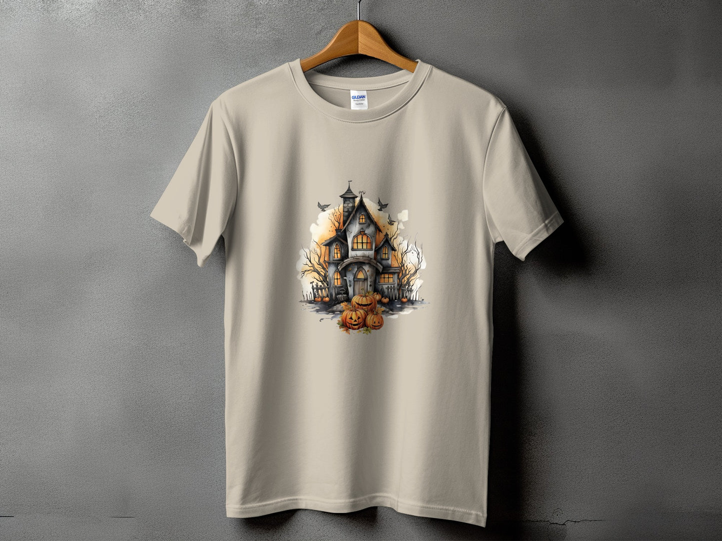 T-shirt with a watercolor illustration of a haunted house and pumpkins.