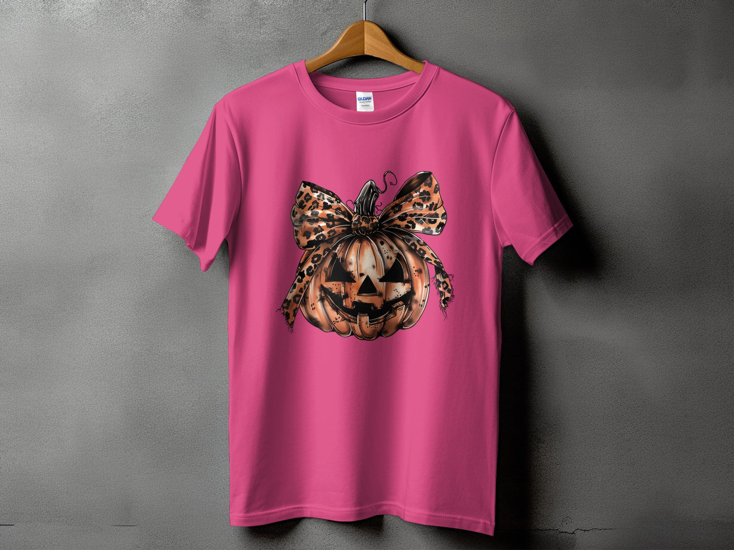 Pink t-shirt with a Halloween jack-o'-lantern graphic with leopard print bow.