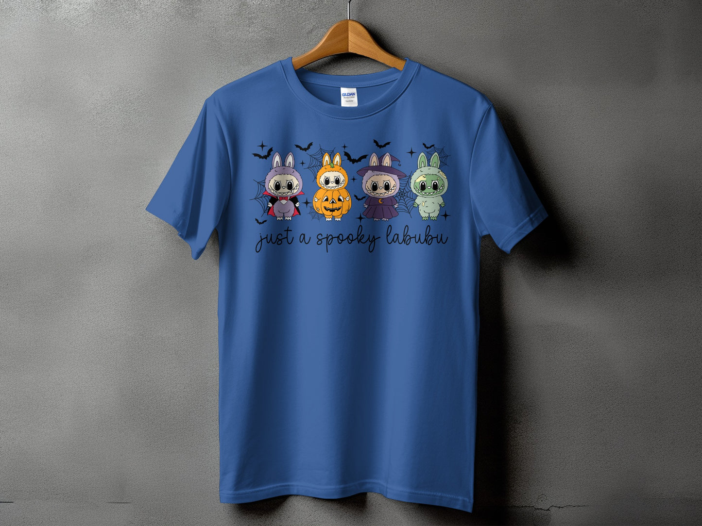 Blue t-shirt with four Halloween-themed Labubu characters and text.