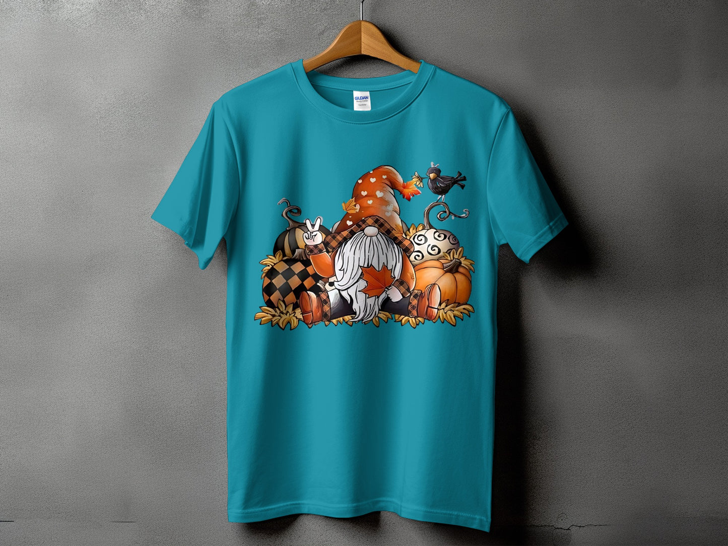 Teal t-shirt with autumn gnome and pumpkin graphic, and bird.