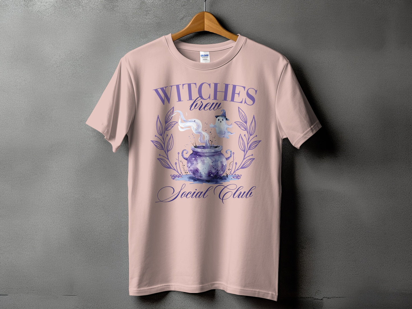 Pink t-shirt with "Witches Brew Social Club" text and Halloween cauldron graphic.