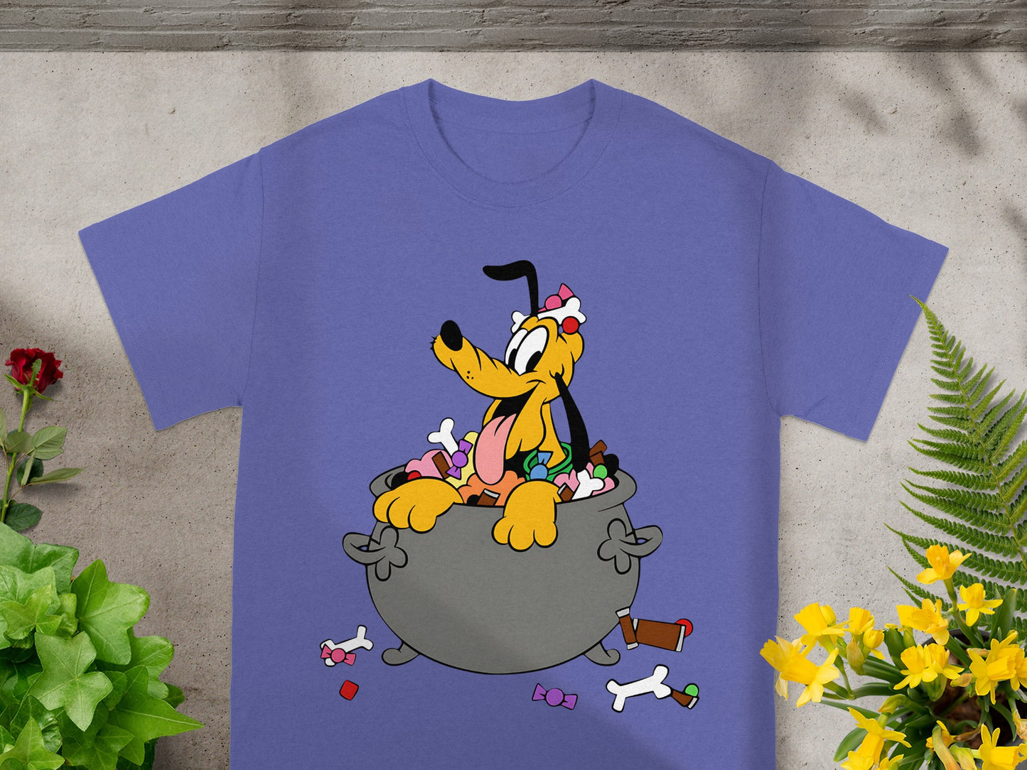 Pluto in a cauldron full of candy, surrounded by scattered treats.