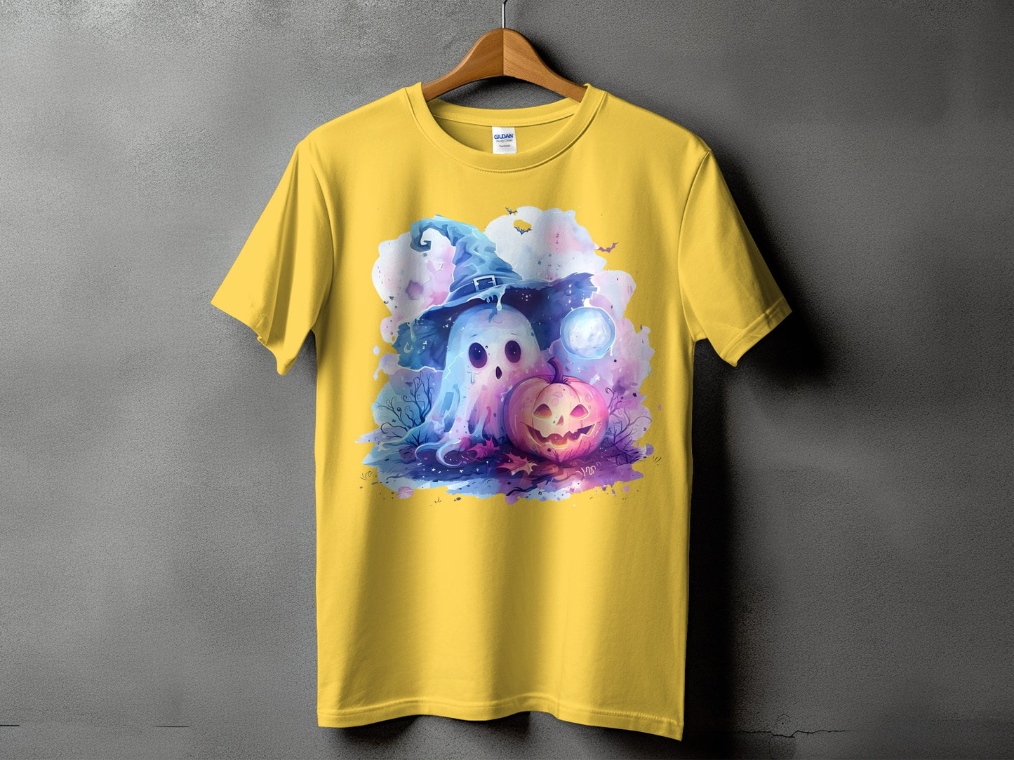 Yellow t-shirt with a watercolor design of a ghost in a witch hat and a jack-o'-lantern.