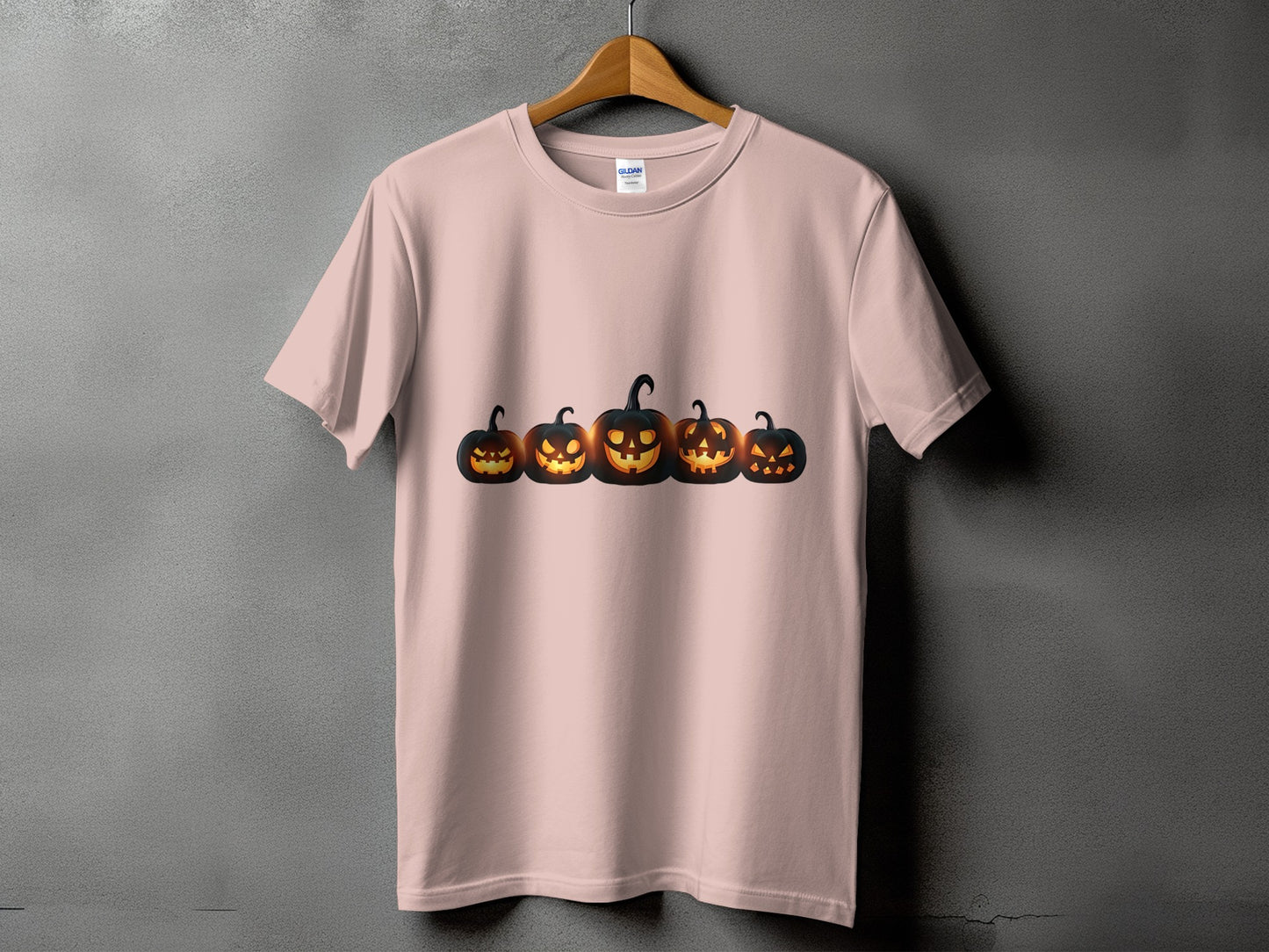 Light pink t-shirt with a row of five glowing jack-o'-lanterns across the chest.
