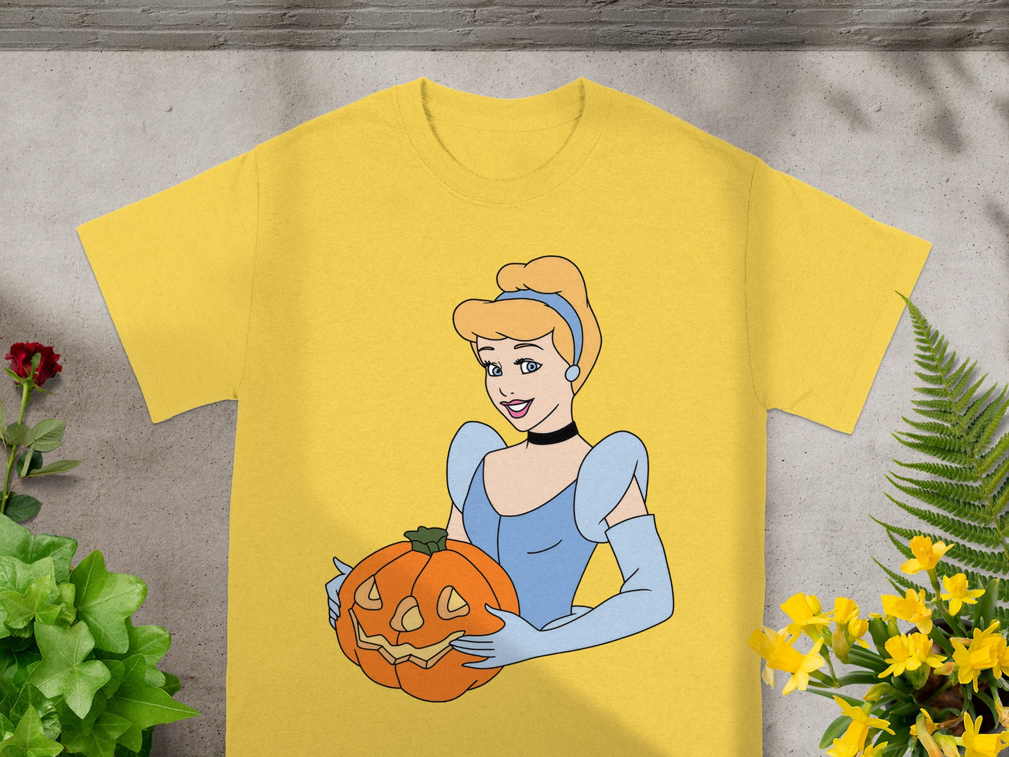 Yellow t-shirt with illustration of Cinderella holding a jack-o'-lantern.
