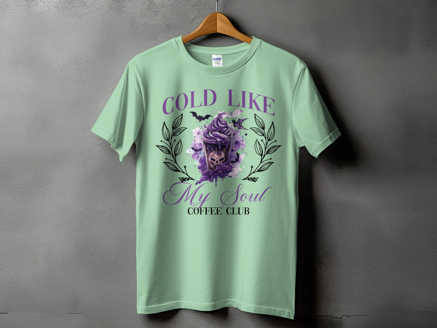 Mint t-shirt with purple "Cold Like My Soul Coffee Club" graphic featuring a skull drink.