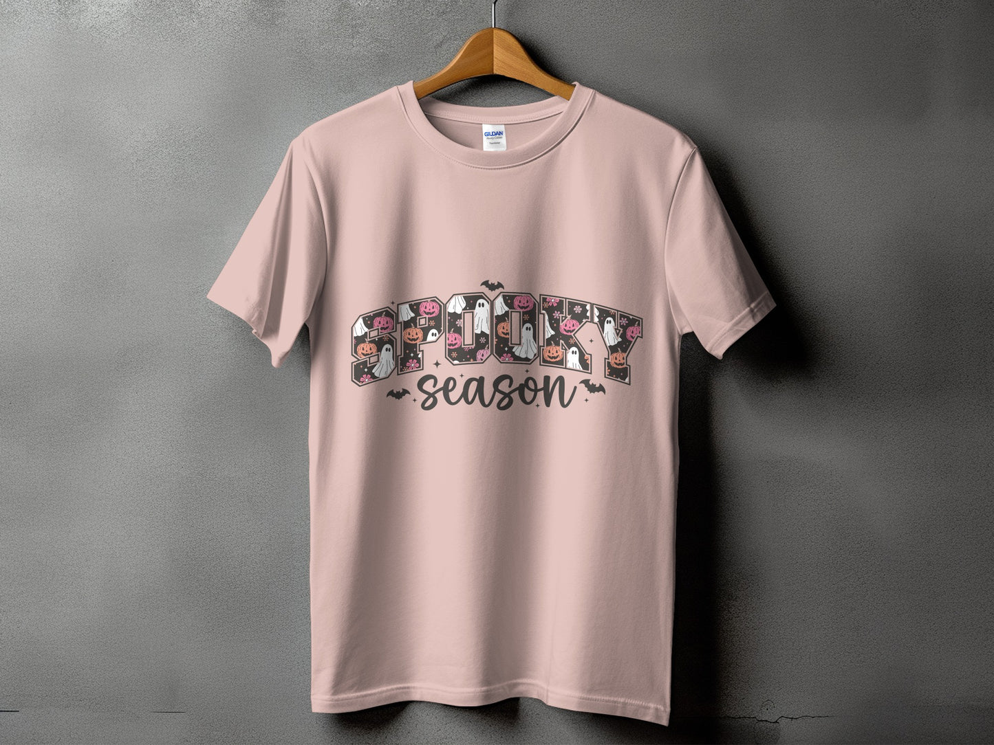Pink t-shirt with "Spooky Season" text featuring Halloween icons.