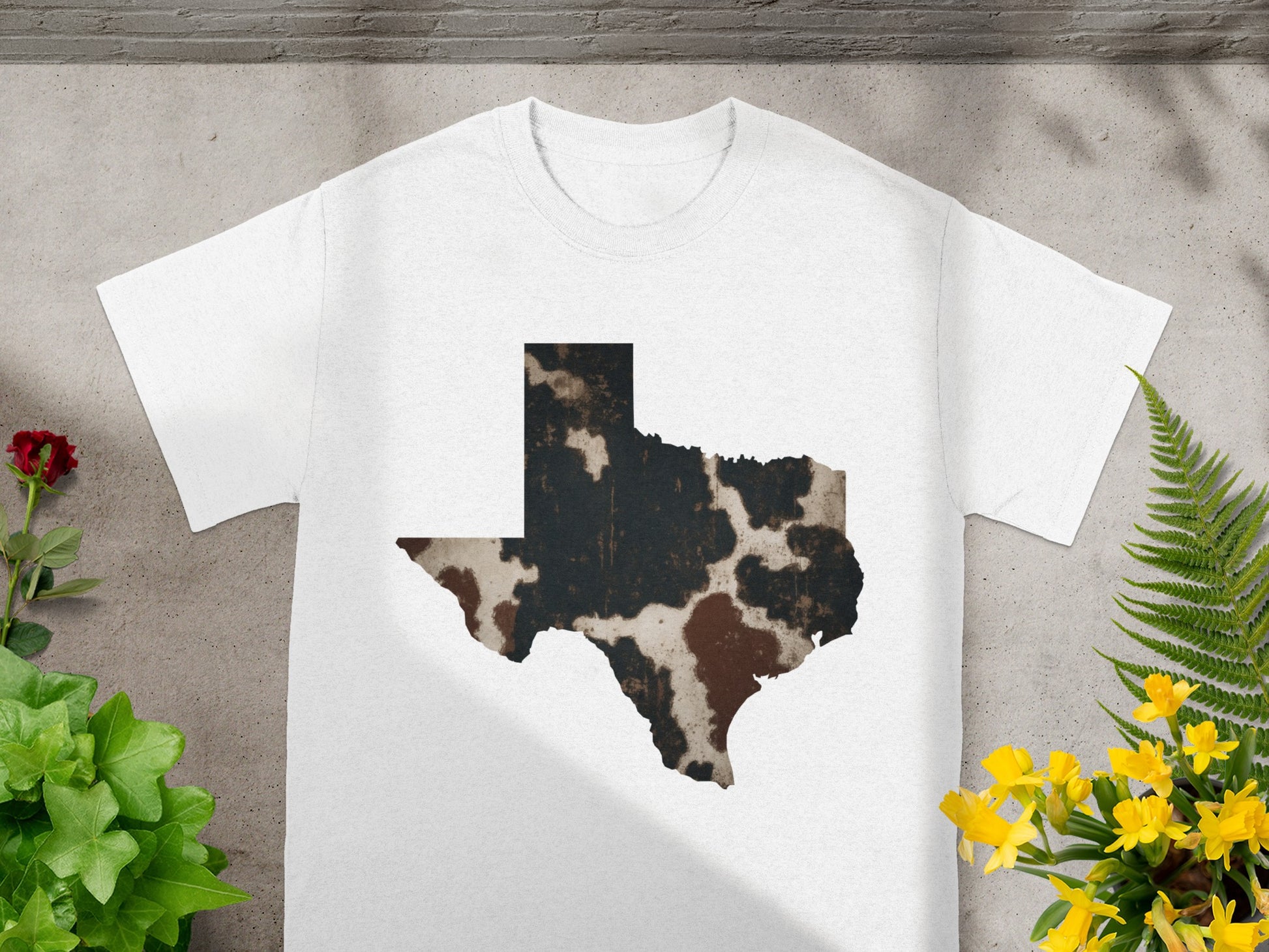 White t-shirt with Texas map graphic in cowhide pattern.