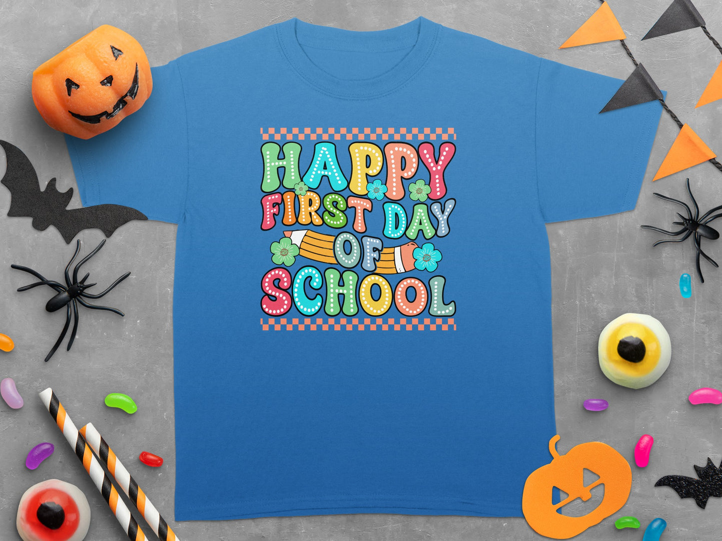 Blue t-shirt with "Happy First Day Of School" text and Halloween decorations.