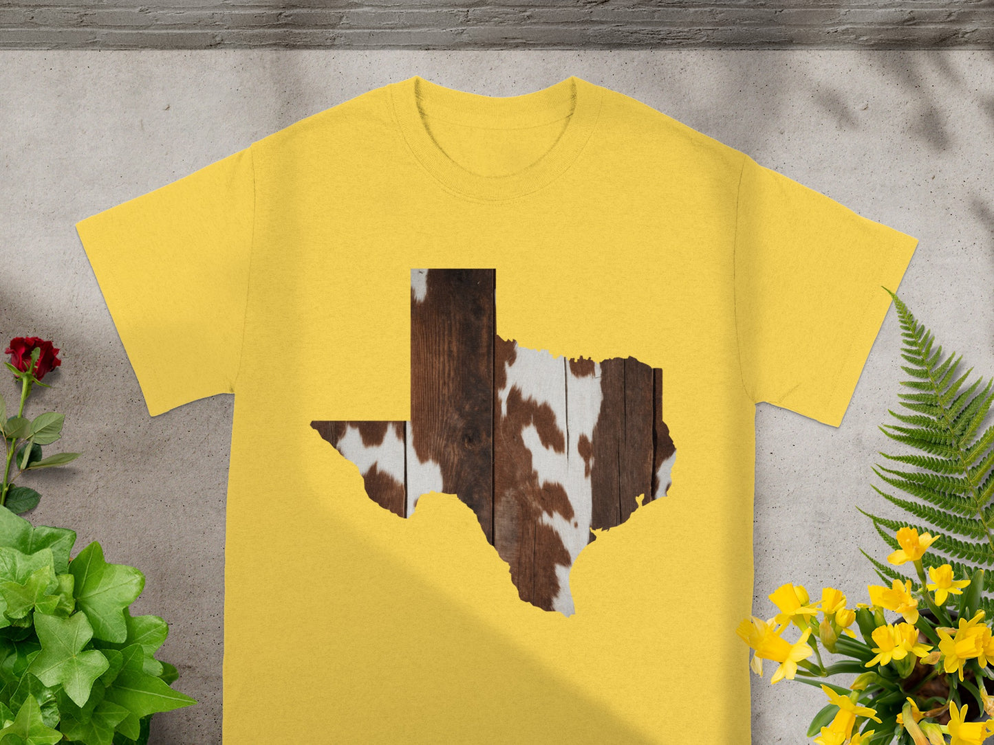 Yellow t-shirt with Texas outline filled with wood and cowhide pattern.