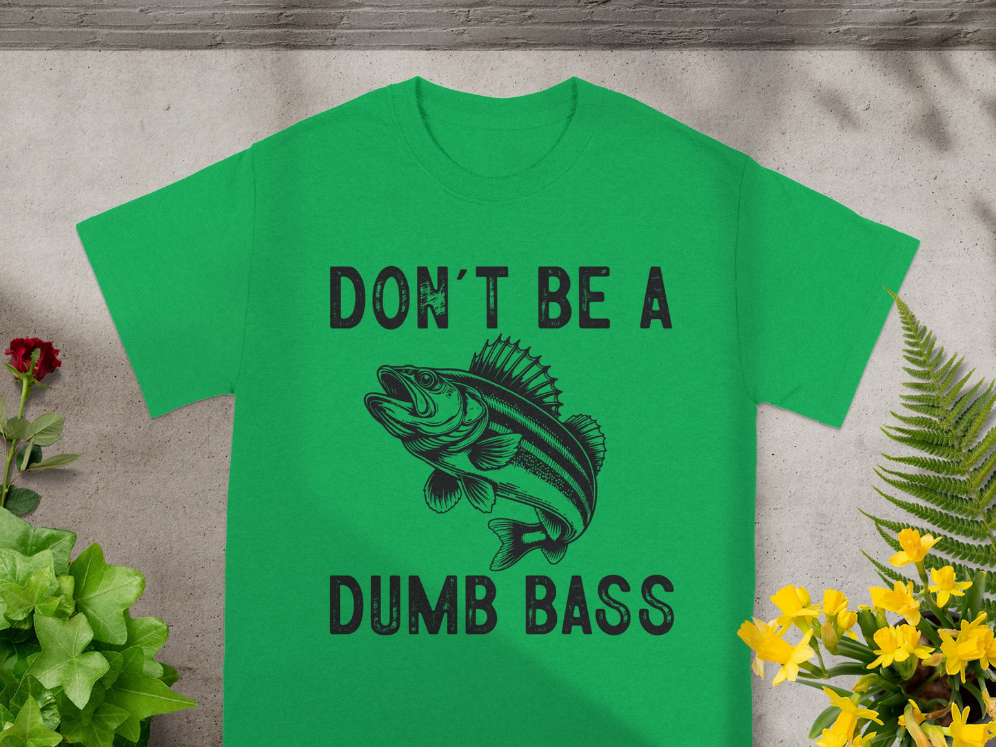Green t-shirt with black text "DON'T BE A DUMB BASS" and a bass fish graphic.