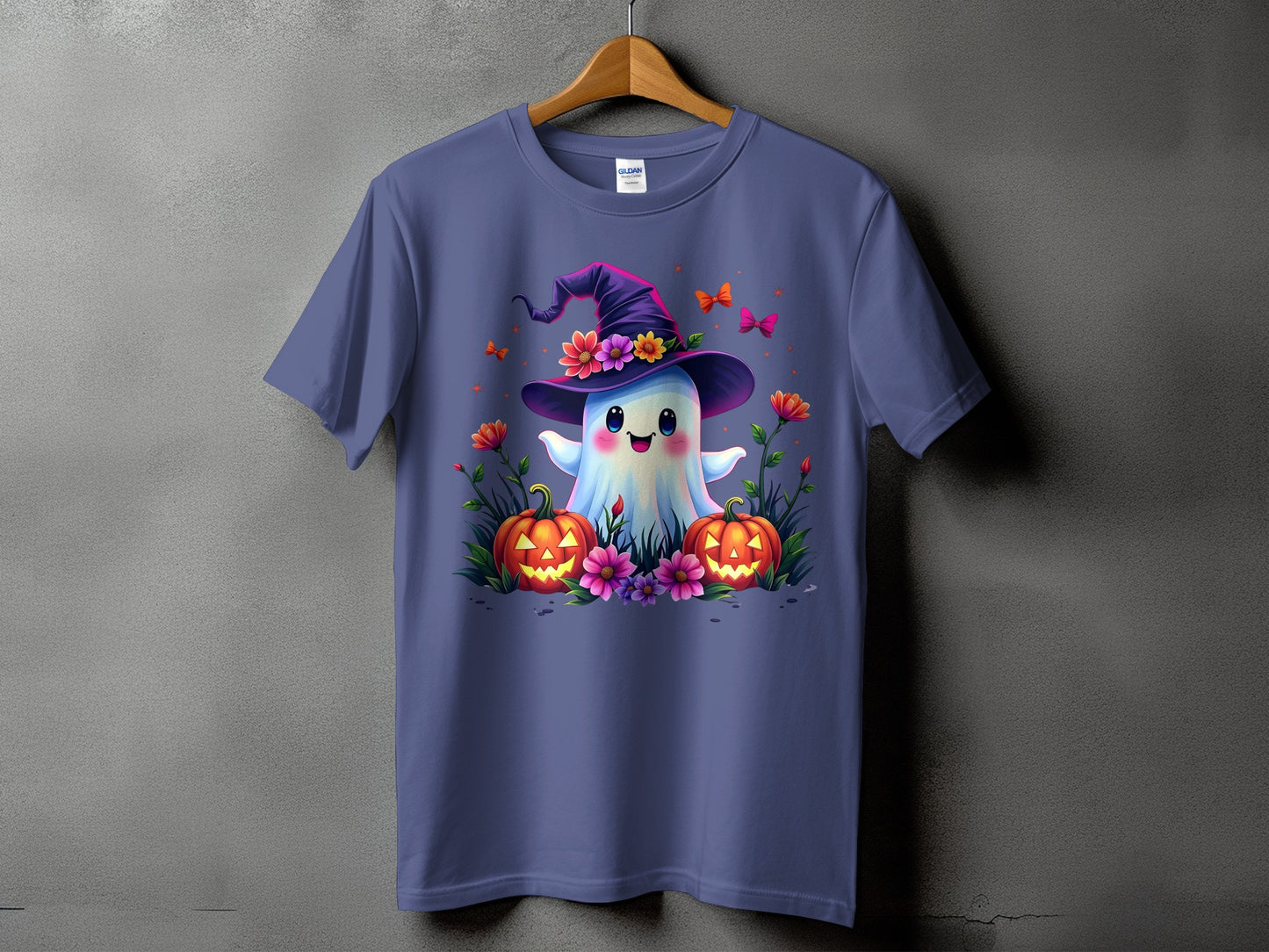 Purple t-shirt with a cute ghost wearing a witch hat surrounded by pumpkins and flowers.